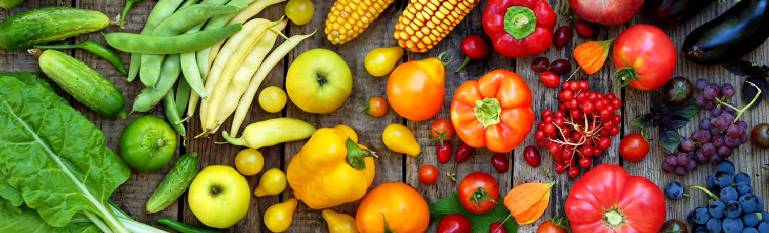 A colorful gradient of vegetables on a wood table.